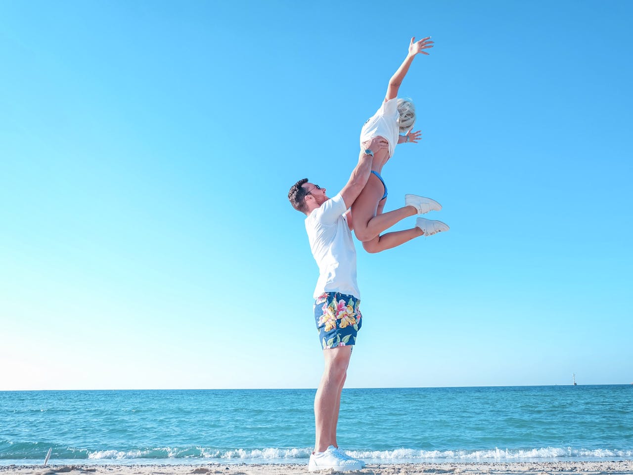 A happy couple at the beach enjoying a playful summer day by the sea.